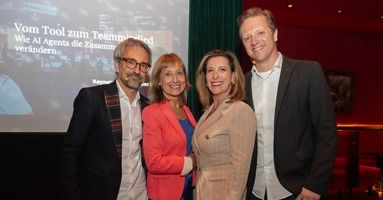 Vier Vortragende posieren gemeinsam beim Event „Reden in der Eden“ in Wien vor einer Präsentationsfolie mit dem Titel „Vom Tool zum Teammitglied – Wie AI Agents die Zusammenarbeit verändern.“